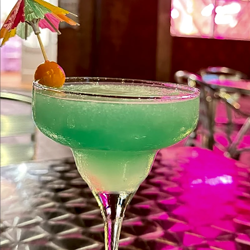 Cóctel azul turquesa refrescante con una sombrillita de papel